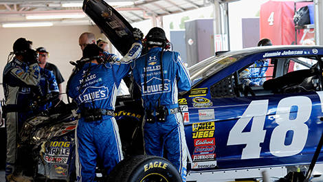 Crew members for Jimmie Johnson, driver of the No. 48 Lowe's Chevrolet, work on the car after the crash.