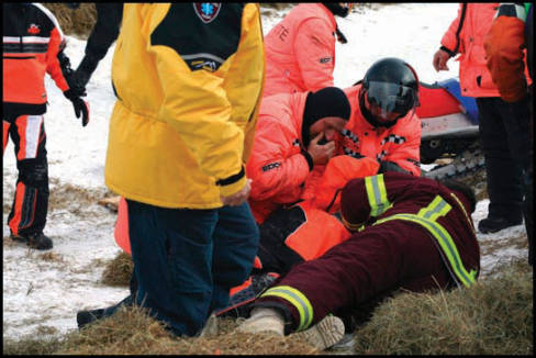 Le blessé Brad Moore a été étendu de longues minutes en bordure de piste avant que les ambulanciers décident de le placer sur une civière et de le transporter à l'hôpital de Sherbrooke. Toutes les précautions d'usage ont été prises avant de le déplacer. Plusieurs préposés à la sécurité et des ambulanciers étaient à son chevet quelques secondes seulement après sa vilaine chute. Heureusement pour Moore, les bottes de foin en bordure de piste ont aidé à ralentir sa chute, car sans cette protection, il aurait pu atterrir directement sur la clôture, comme ce fut le cas de sa machine. (Photo: Dany Flageole)