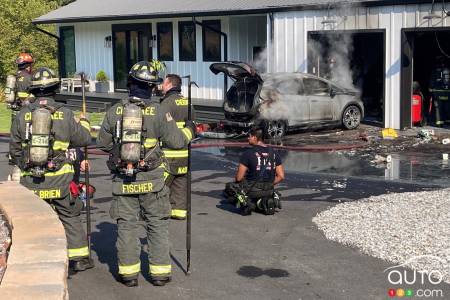 Firemen in front of the burned Chevrolet Bolt EV
