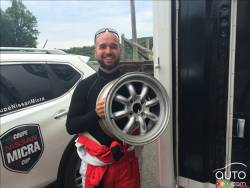 Matt St-Pierre qui tient une roue de 15 pouces de la Coupe Nissan Micra