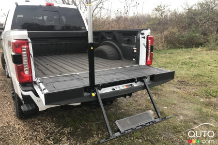 The bed of the 2023 F-250, with its tailgate open, and the steps deployed.