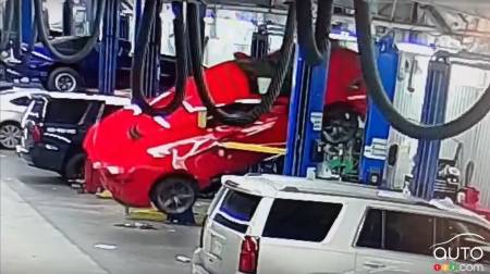 The side of the Corvette is impaled by the fork of the lift