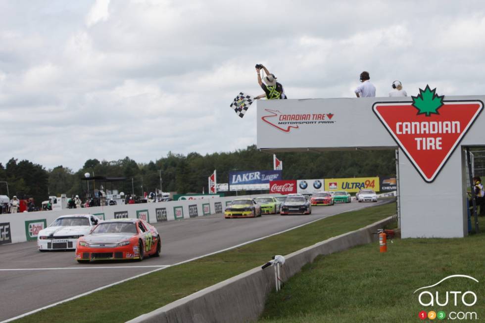 Le drapeau à damiers est donné alors que les voiture sont immobilisées sur la ligne d'arrivée lors d'un drapeau rouge