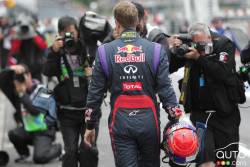 Sebastian Vettel marche le long de la ligne des puits après que sa voiture soit retenue à l'inspection technique.
