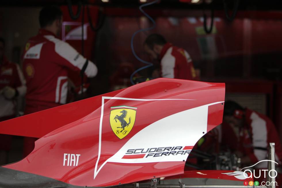 Part of a Ferrari in front of their garage.