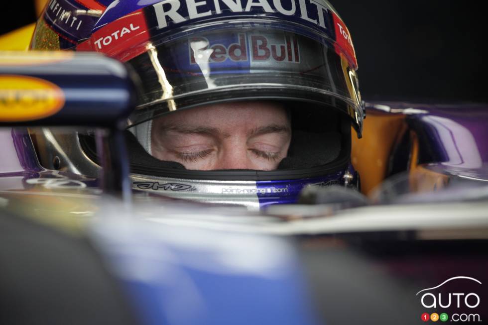 Sebastian Vettel sits in his car in the Infiniti Red Bull garage.