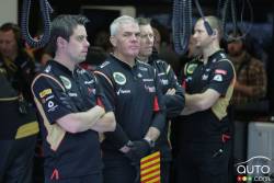 Lotus team members follow the action from within their pit garage.