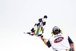 A NASCAR official waves the checkered flag during qualifying